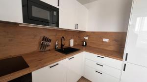 a kitchen with white cabinets and a wooden counter top at 2 room Apartment with terrace, new building, 35 in Bratislava