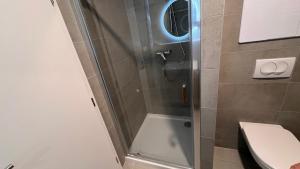 ducha con puerta de cristal junto a un aseo en 2 room Apartment with terrace, new building, 35 en Bratislava