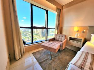 Habitación de hotel con silla y ventana grande en Cullinan 1110E · Hotel Cullinan Luxury Premium quarto com vista, en Brasilia