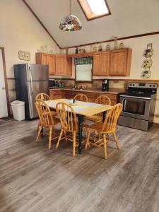 a kitchen with a table and chairs and a refrigerator at Optimum #9 with Hot Tub and Jacuzzi on Patoka Lake in Southern Indiana in Tunnelton
