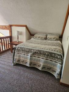 a bedroom with a bed and a table with a lamp at Optimum #9 with Hot Tub and Jacuzzi on Patoka Lake in Southern Indiana in Tunnelton