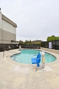 a swimming pool with a blue chair in front of a building at Comfort Inn Yreka I-5 in Yreka