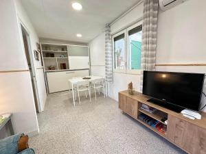 ein Wohnzimmer mit einem Flachbild-TV und einem Tisch in der Unterkunft Apartamento con terraza Delta Slow in Deltebre
