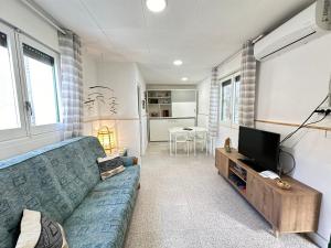 a living room with a blue couch and a television at Apartamento con terraza Delta Slow in Deltebre