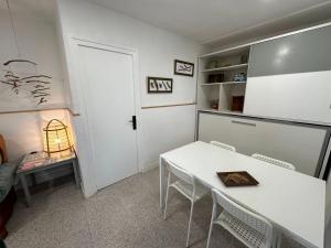 ein weißes Esszimmer mit einem Tisch und Stühlen in der Unterkunft Apartamento con terraza Delta Slow in Deltebre