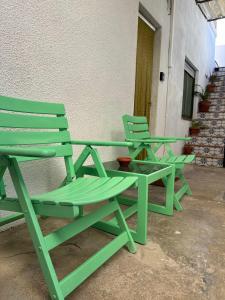 two green chairs sitting next to a building at Apartamento con terraza Delta Slow in Deltebre