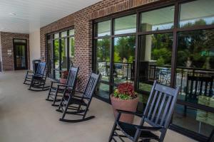 SpringHill Suites by Marriott Charleston Mount Pleasant في تشارلستون: صف من الكراسي جالس امام مبنى
