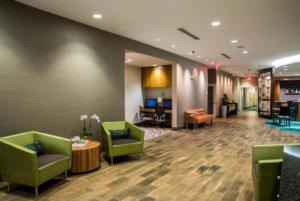 un hall d'un hôtel avec des chaises et des tables vertes dans l'établissement SpringHill Suites by Marriott Charleston Mount Pleasant, à Charleston