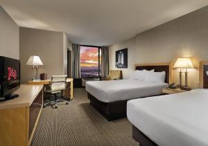 a hotel room with two beds and a desk and a television at Plaza Hotel & Casino in Las Vegas