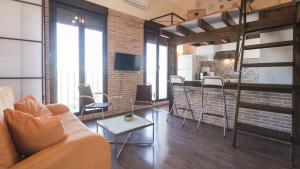 a living room with a couch and a table and a kitchen at Apartamentos Zocosol by Toledo AP in Toledo