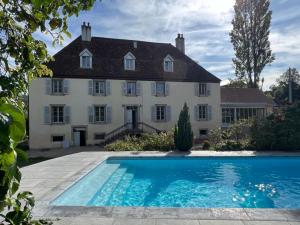 a large house with a swimming pool in front of it at Le Clos Alice - Hôtel et Spa, Arbois in Arbois
