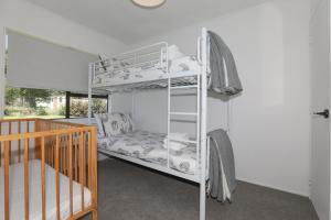 Zimmer mit Etagenbett und Kinderbett in der Unterkunft Rad Little Pad in Rotorua