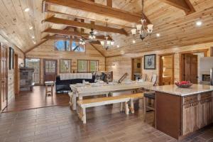 een grote keuken met een tafel in een blokhut bij Mountain Majesty ~ 28 Person Indoor Pool Cabin in Sevierville