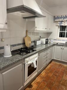 a kitchen with white cabinets and a stove top oven at Casa Da Praia in Luz