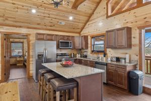 een keuken met een groot eiland in een houten huisje bij Mountain Majesty ~ 28 Person Indoor Pool Cabin in Sevierville