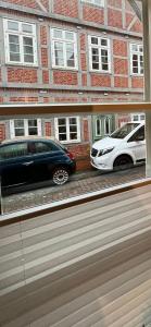 two cars parked in front of a brick building at Gemütliche Ferienwohnung mitten in der historischen Stader Altstadt in Stade