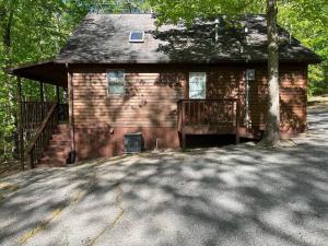 a small brick house with a tree in front of it at Deluxe Cabin #10 with Jacuzzi on Patoka Lake in Southern Indiana in Seymour