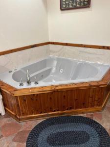 a bath tub with a wooden frame in a bathroom at Deluxe Cabin #10 with Jacuzzi on Patoka Lake in Southern Indiana in Seymour