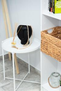 a white table with a black vase and a basket at Zoe's House in Polykárpion