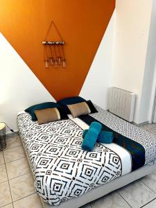 a bed in a room with an orange and white at Studio A au pied des Thermes de Néris-les-Bains in Néris-les-Bains