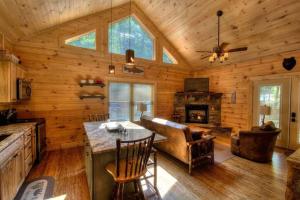 a kitchen and living room of a log cabin at Honeymoon Getaway in woods near NOC and Smoky Mtn RR in Bryson City