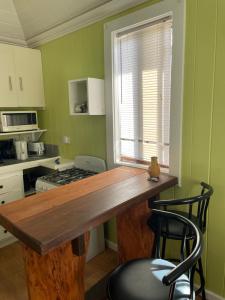 a kitchen with green walls and a wooden counter top at Montete Cottages in Choiseul
