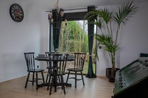 a dining room with a table and chairs and a clock at Meerbeek Unwind in Kortenberg