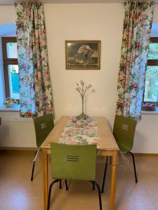 a dining room table with two chairs and a vase on it at Energietanken vor den Toren Dresdens -barrierefrei- in Dippoldiswalde