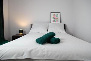 a green stuffed animal laying on a white bed at Meerbeek Unwind in Kortenberg