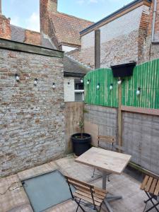 a patio with a wooden table and two chairs at Le rustiques Moderne de la Raquette in Mons