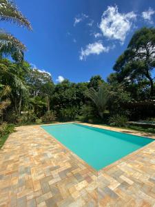 basen w ogrodzie z drzewami i niebieskim niebem w obiekcie Casa de Campo Pampulha w mieście Belo Horizonte