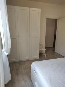 1 dormitorio blanco con armarios blancos y 1 cama en Casa Tommaso, en Deiva Marina