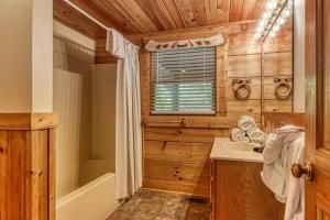 a bathroom with a tub and a sink in a log cabin at Heavenly Peace in Pigeon Forge +62 photos