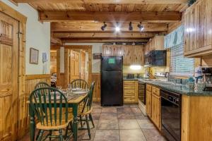a kitchen with a table and chairs and a refrigerator at Heavenly Peace in Pigeon Forge
