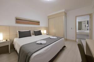 a bedroom with a large bed with towels on it at Hotel Mont Blanc Premium in Ribeirão Preto