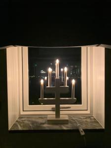 ein Kreuz vor einem Fenster mit Kerzen in der Unterkunft Hus med pool, badtunna och 450 m till havet in Beddinge Strand