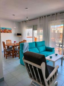 a living room with a blue couch and a table at ApartiaBeach Apartamentos in Alcossebre