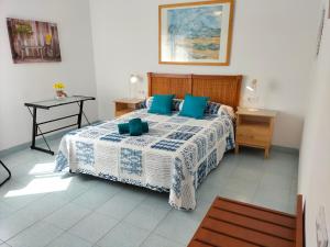 a bedroom with a bed with a blue and white comforter at ApartiaBeach Apartamentos in Alcossebre