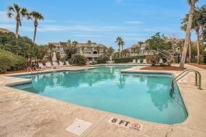 a large swimming pool with palm trees and houses at 6C Mariners AvantStay Easy Pool Beach Access in Isle of Palms