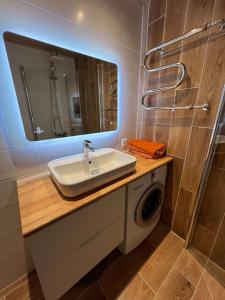 a bathroom with a sink and a washing machine at Mugavustega korter pargi serval in Jõhvi