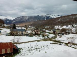 a village in the snow with mountains in the background at Appartement vallée de Campan in Campan