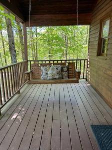 a wooden porch with a bench on a house at Two Bedroom Cozy Cabin #14 on Patoka Lake in Southern Indiana in Paoli