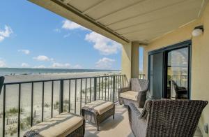 a balcony with chairs and a view of the beach at 211 Seascape by AvantStay Oceanfront View Pool in Isle of Palms