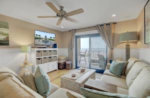 a living room with a couch and a ceiling fan at 211 Seascape by AvantStay Oceanfront View Pool in Isle of Palms