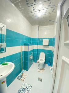 a blue and white bathroom with a toilet and a sink at HOSTEL BORDJ ELKIFFAN in Fort de lʼEau