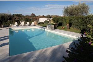einen Pool mit blauem Wasser im Hof in der Unterkunft Trullo Imperiale in Cisternino