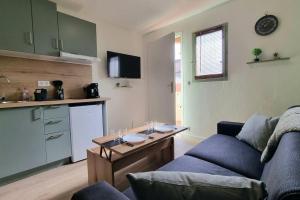 a living room with a couch and a table and a kitchen at Chez K&D Studio Zen in Saint-Raphaël