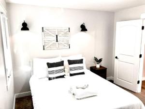 a white bedroom with a large bed with two pillows at The Cove by the North Shore in Forest Lake