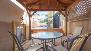a patio with a table and chairs on a balcony at Amazing villa ideal for golf or family holidays in Villamartin +34 photos