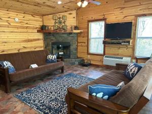 a living room with two couches and a fireplace at Solarium Cabin #16 on Patoka Lake in Southern Indiana in Seymour
